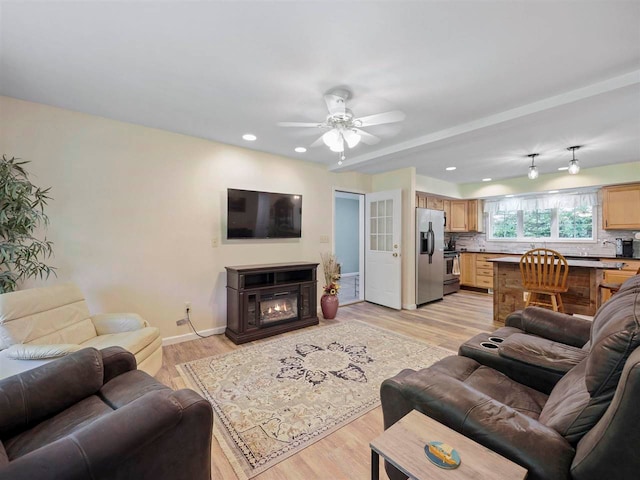 2729 Ranney Rd, East Jordan, MI 49727 - living room featuring ceiling fan, light wood finished floors, recessed lighting, baseboards, and a glass covered fireplace