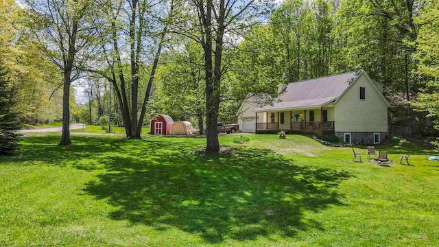 2729 Ranney Rd, East Jordan, MI 49727 - view of green lawn with a storage shed and an outbuilding
