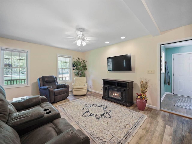 2729 Ranney Rd, East Jordan, MI 49727 - living room featuring wood finished floors, a ceiling fan, baseboards, a glass covered fireplace, and recessed lighting