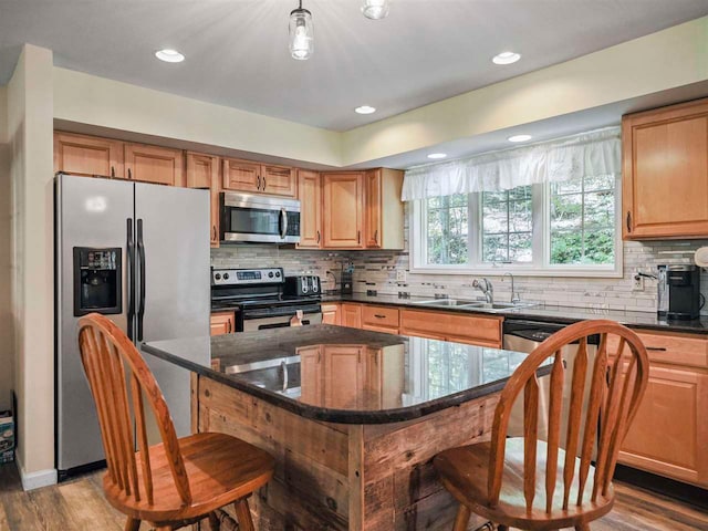 2729 Ranney Rd, East Jordan, MI 49727 - kitchen featuring appliances with stainless steel finishes, a sink, a breakfast bar, decorative backsplash, and recessed lighting