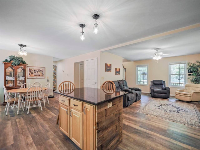 2729 Ranney Rd, East Jordan, MI 49727 - kitchen with dark wood-type flooring, a center island, hanging light fixtures, ceiling fan, and dark stone counters