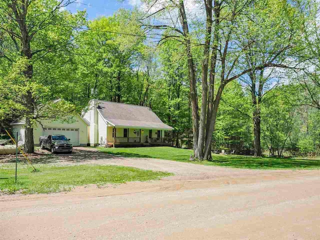 2729 Ranney Rd, East Jordan, MI 49727 - view of front of home with driveway, an attached garage, covered porch, and a front yard