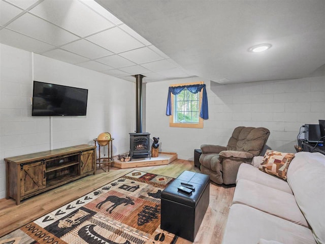 2729 Ranney Rd, East Jordan, MI 49727 - living room with light wood-style floors, a wood stove, and concrete block wall