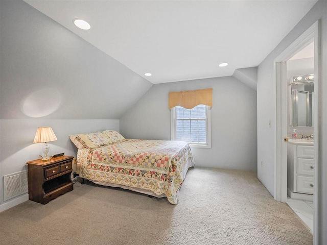 2729 Ranney Rd, East Jordan, MI 49727 - bedroom with carpet, vaulted ceiling, recessed lighting, ensuite bathroom, and a sink