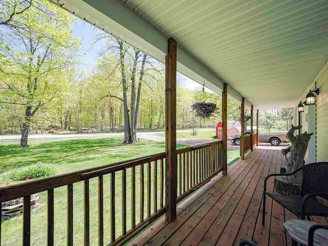 2729 Ranney Rd, East Jordan, MI 49727 - deck featuring a porch and a yard