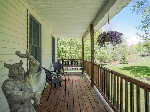 2729 Ranney Rd, East Jordan, MI 49727 - wooden terrace with covered porch and a yard