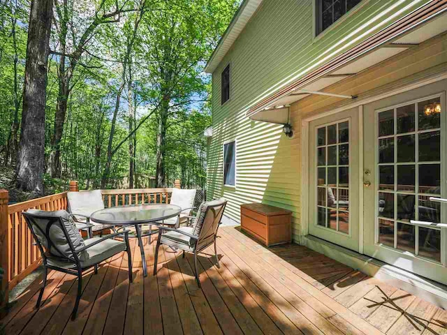 2729 Ranney Rd, East Jordan, MI 49727 - wooden terrace with french doors and outdoor dining area