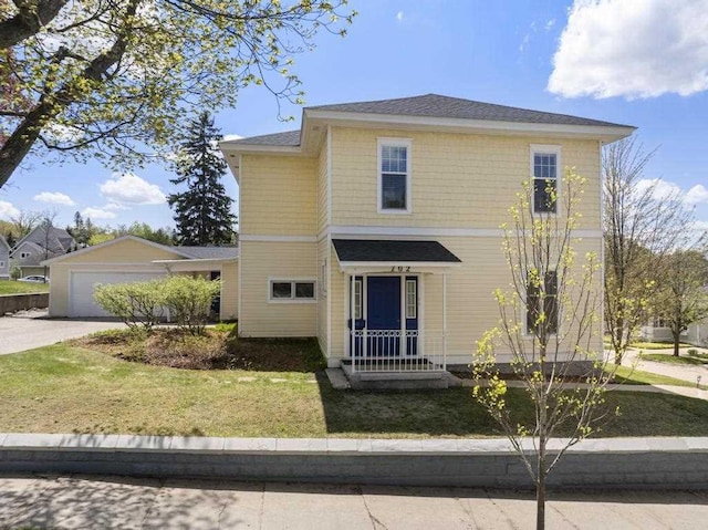 702 Michigan, Petoskey, MI 49770 - view of front of house featuring a front lawn, driveway, and an attached garage