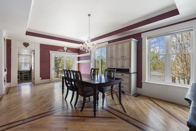 702 Michigan, Petoskey, MI 49770 - dining area featuring a raised ceiling, a chandelier, ornamental molding, baseboards, and light wood-style floors