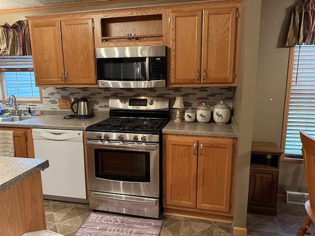 15500 Riverside Trl, Wolverine, MI 49799 - kitchen with appliances with stainless steel finishes, a sink, backsplash, and light countertops