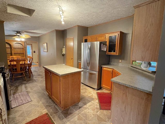 15500 Riverside Trl, Wolverine, MI 49799 - kitchen with stainless steel appliances, a center island, ceiling fan, crown molding, and a textured ceiling
