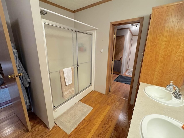 15500 Riverside Trl, Wolverine, MI 49799 - full bathroom with wood finished floors, ornamental molding, a stall shower, and double vanity