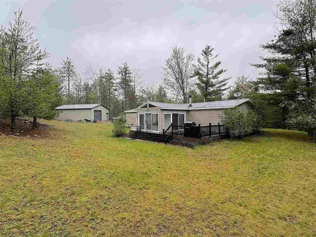 15500 Riverside Trl, Wolverine, MI 49799 - view of green lawn featuring a deck and a detached garage