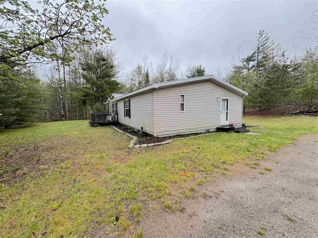 15500 Riverside Trl, Wolverine, MI 49799 - view of side of home featuring a yard