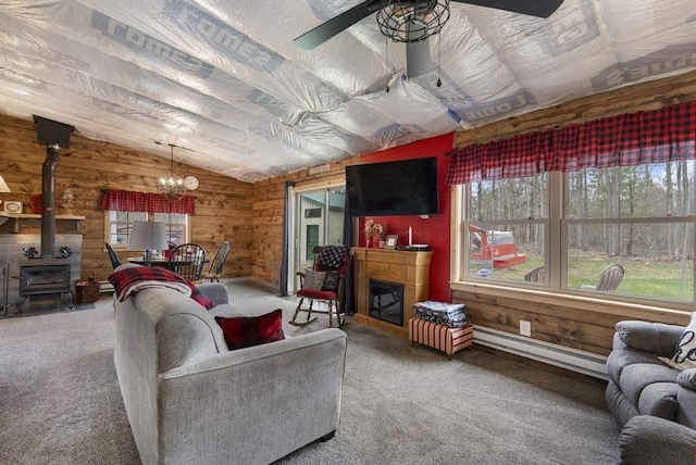 3622 Big Sky Trl, Gaylord, MI 49735 - living room with baseboard heating, carpet floors, plenty of natural light, lofted ceiling, and wood walls