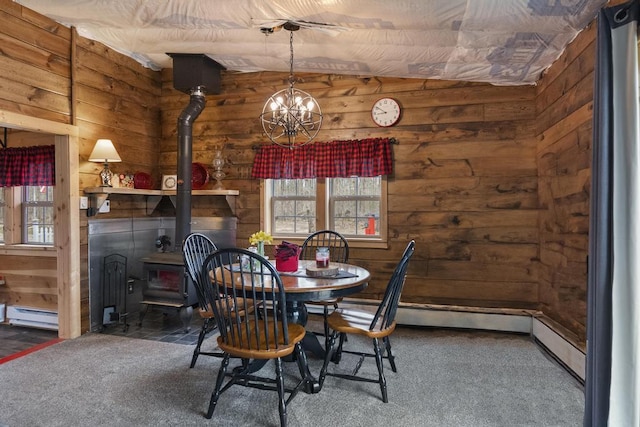 3622 Big Sky Trl, Gaylord, MI 49735 - carpeted dining space with a wood stove, wooden walls, a baseboard heating unit, and a chandelier