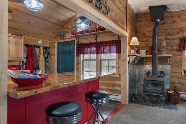 3622 Big Sky Trl, Gaylord, MI 49735 - bar area featuring a wood stove, lofted ceiling, wooden walls, and a baseboard radiator
