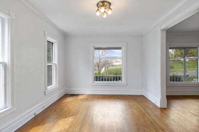 612 E Mitchell St, Petoskey, MI 49770 - empty room with plenty of natural light, wood finished floors, baseboards, and crown molding