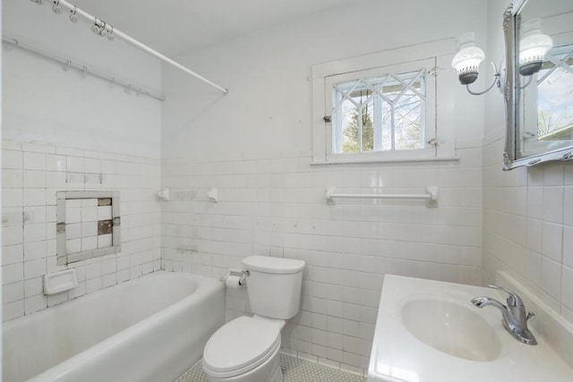 612 E Mitchell St, Petoskey, MI 49770 - bathroom with tile walls, toilet, a bathtub, a wainscoted wall, and vanity