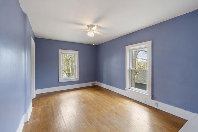 612 E Mitchell St, Petoskey, MI 49770 - empty room with a ceiling fan, wood-type flooring, healthy amount of natural light, and baseboards