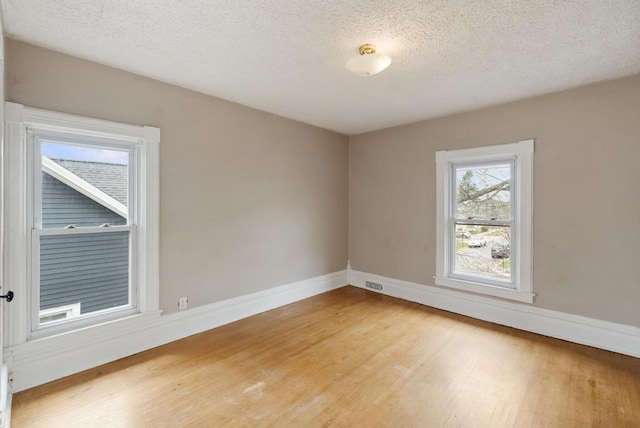 612 E Mitchell St, Petoskey, MI 49770 - empty room featuring wood finished floors, baseboards, and a textured ceiling