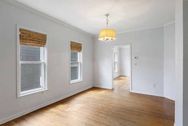 612 E Mitchell St, Petoskey, MI 49770 - unfurnished room with a chandelier, crown molding, light wood-type flooring, and baseboards