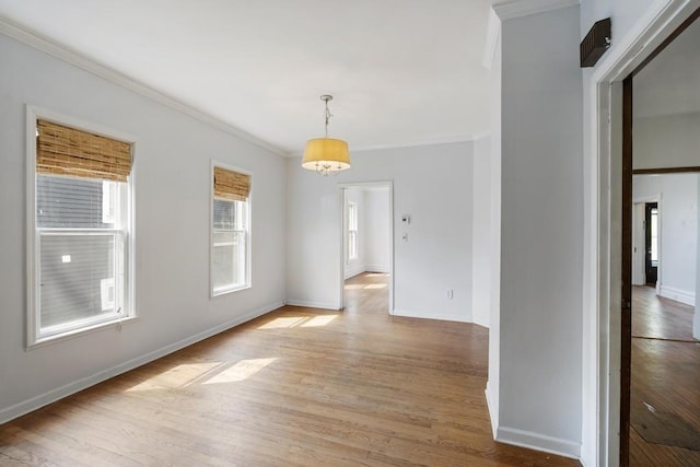 612 E Mitchell St, Petoskey, MI 49770 - spare room featuring ornamental molding, light wood-type flooring, and baseboards