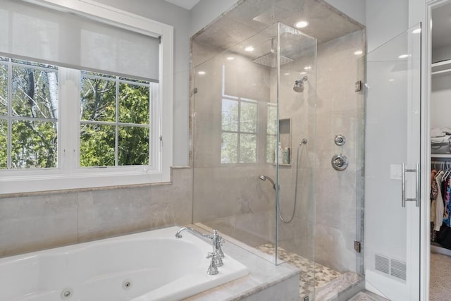 4435 Lake Shore Dr, Charlevoix, MI 49720 - bathroom featuring a jetted tub, a stall shower, healthy amount of natural light, and a spacious closet