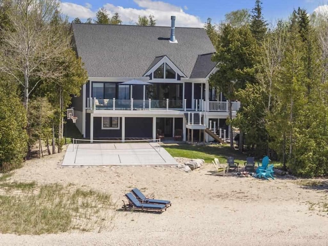 4435 Lake Shore Dr, Charlevoix, MI 49720 - rear view of house with an outdoor fire pit, a patio, stairway, and a shingled roof