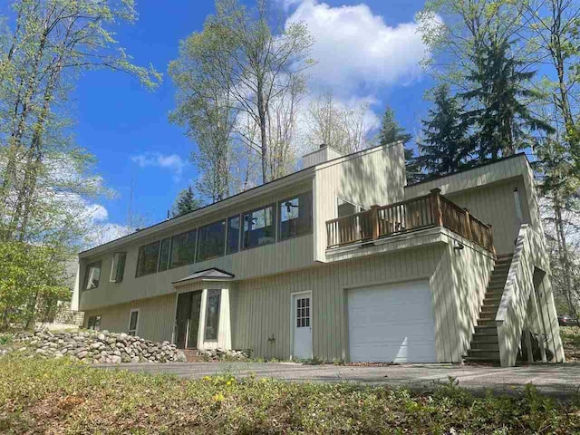 3237 Greenbriar, Harbor Springs, MI 49740 - rear view of property with a balcony, an attached garage, and a chimney