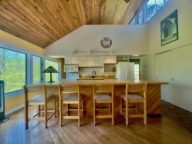 3237 Greenbriar, Harbor Springs, MI 49740 - kitchen with white appliances, a sink, white cabinets, light countertops, and high vaulted ceiling