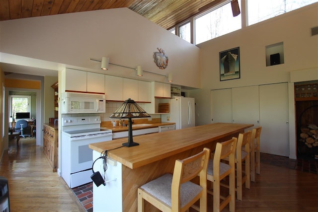 3237 Greenbriar, Harbor Springs, MI 49740 - kitchen with white appliances, high vaulted ceiling, butcher block counters, white cabinets, and backsplash