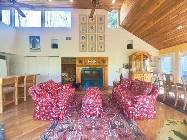 3237 Greenbriar, Harbor Springs, MI 49740 - living room with a ceiling fan, high vaulted ceiling, wood finished floors, wooden ceiling, and a fireplace with flush hearth