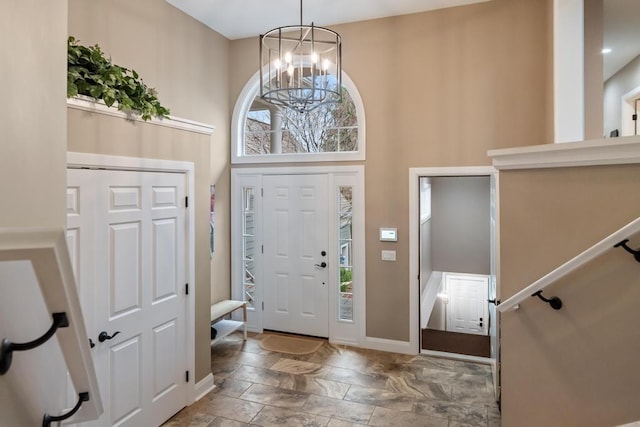 4104 Harborview Rdg Unit 28, Bay Harbor, MI 49770 - entrance foyer featuring a chandelier, baseboards, stone finish floors, and a towering ceiling