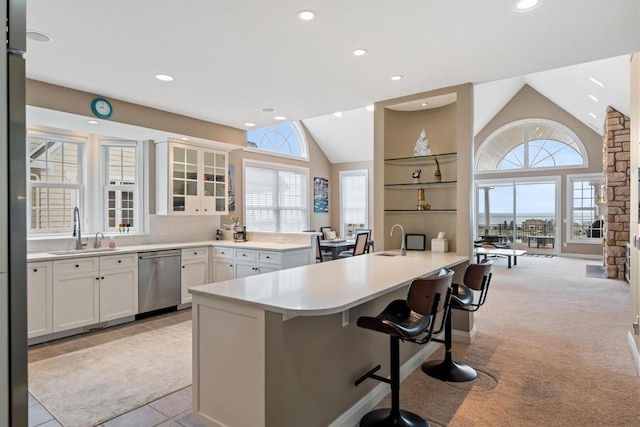 4104 Harborview Rdg Unit 28, Bay Harbor, MI 49770 - kitchen featuring stainless steel dishwasher, a sink, vaulted ceiling, plenty of natural light, and a kitchen breakfast bar