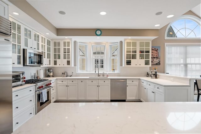 4104 Harborview Rdg Unit 28, Bay Harbor, MI 49770 - kitchen with high quality appliances, a sink, light stone countertops, white cabinetry, and recessed lighting