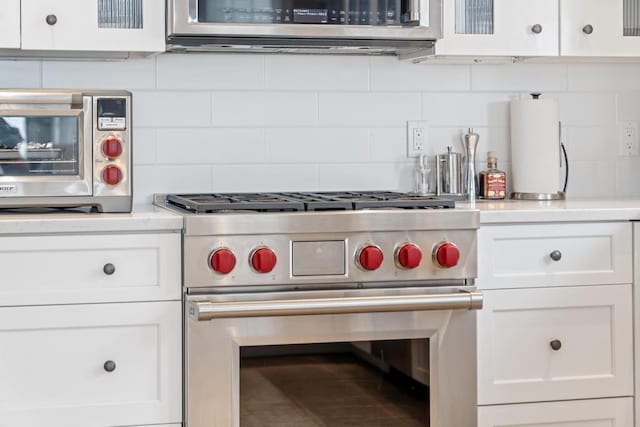 4104 Harborview Rdg Unit 28, Bay Harbor, MI 49770 - kitchen with luxury range, white cabinetry, light countertops, and decorative backsplash