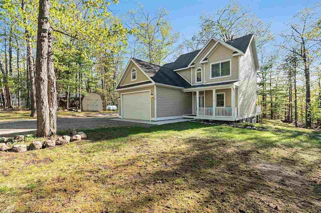 1766 Chippewa Bch, Indian River, MI 49749 - view of front of home with covered porch, a storage shed, an attached garage, and a front yard