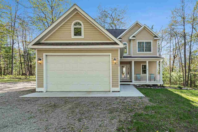 1766 Chippewa Bch, Indian River, MI 49749 - traditional-style house featuring a porch, driveway, and roof with shingles