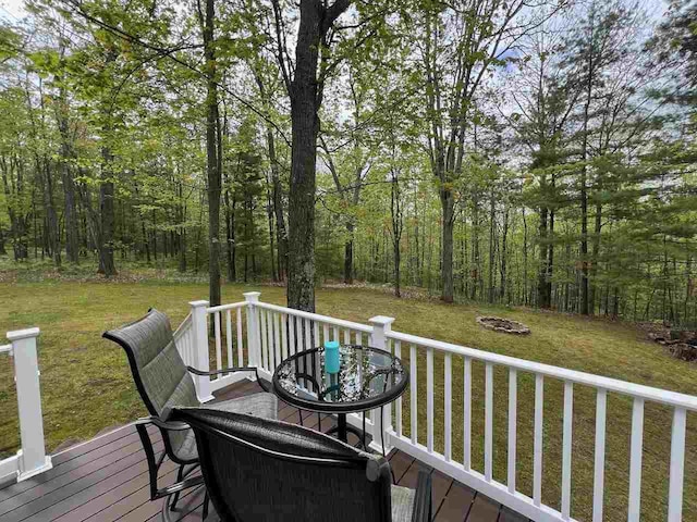 1766 Chippewa Bch, Indian River, MI 49749 - wooden terrace featuring an outdoor fire pit, a lawn, and a forest view