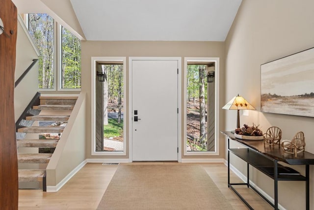 2018 Greenbriar Ter, Harbor Springs, MI 49740 - entrance foyer featuring lofted ceiling, wood finished floors, plenty of natural light, stairway, and baseboards