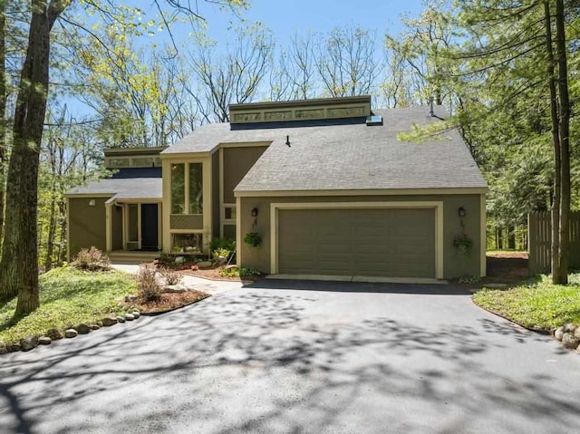 2018 Greenbriar Ter, Harbor Springs, MI 49740 - view of front of home featuring driveway, a garage, stucco siding, and a shingled roof