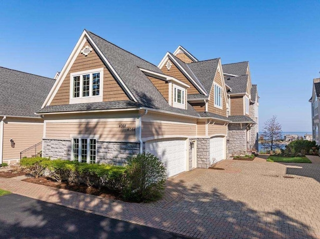 4064 Harborview Rdg Unit 17, Bay Harbor, MI 49770 - view of side of property with driveway, stone siding, and a garage