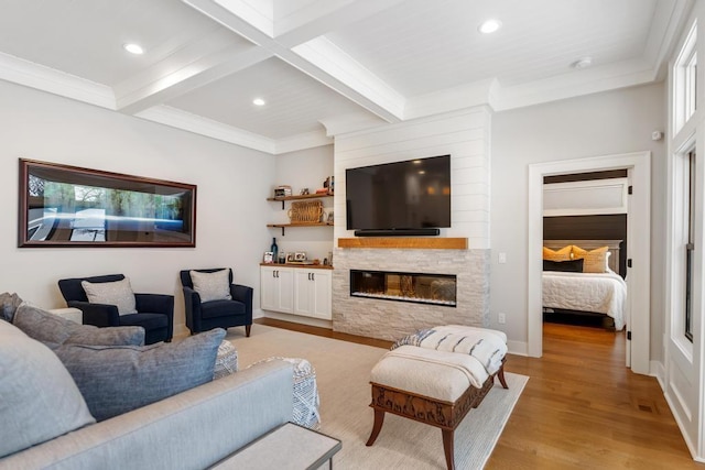 917 Grove St, Petoskey, MI 49770 - living area featuring light wood-style flooring, beamed ceiling, recessed lighting, a stone fireplace, and ornamental molding