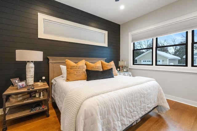 917 Grove St, Petoskey, MI 49770 - bedroom featuring multiple windows, baseboards, wood finished floors, wood walls, and recessed lighting