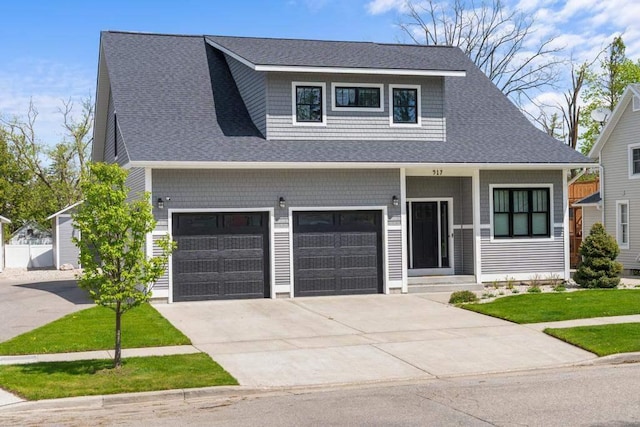 917 Grove St, Petoskey, MI 49770 - view of front of home featuring concrete driveway, a garage, a shingled roof, and a front yard
