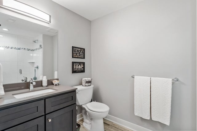 917 Grove St, Petoskey, MI 49770 - bathroom featuring a stall shower, toilet, baseboards, vanity, and wood finished floors