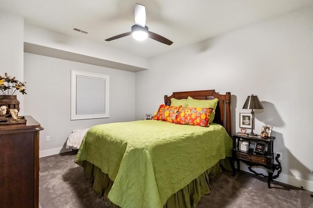 917 Grove St, Petoskey, MI 49770 - carpeted bedroom featuring baseboards, a ceiling fan, and a wood stove