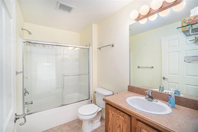 1556 Emerald Ct Unit 89, Petoskey, MI 49770 - bathroom featuring toilet, vanity, tile patterned floors, and bath / shower combo with glass door