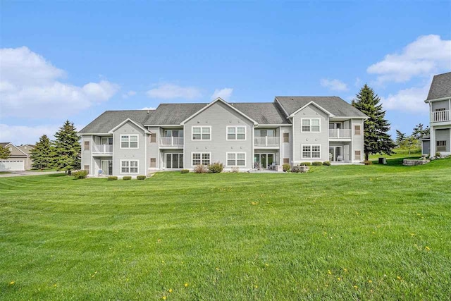 1556 Emerald Ct Unit 89, Petoskey, MI 49770 - rear view of house with a lawn and a balcony